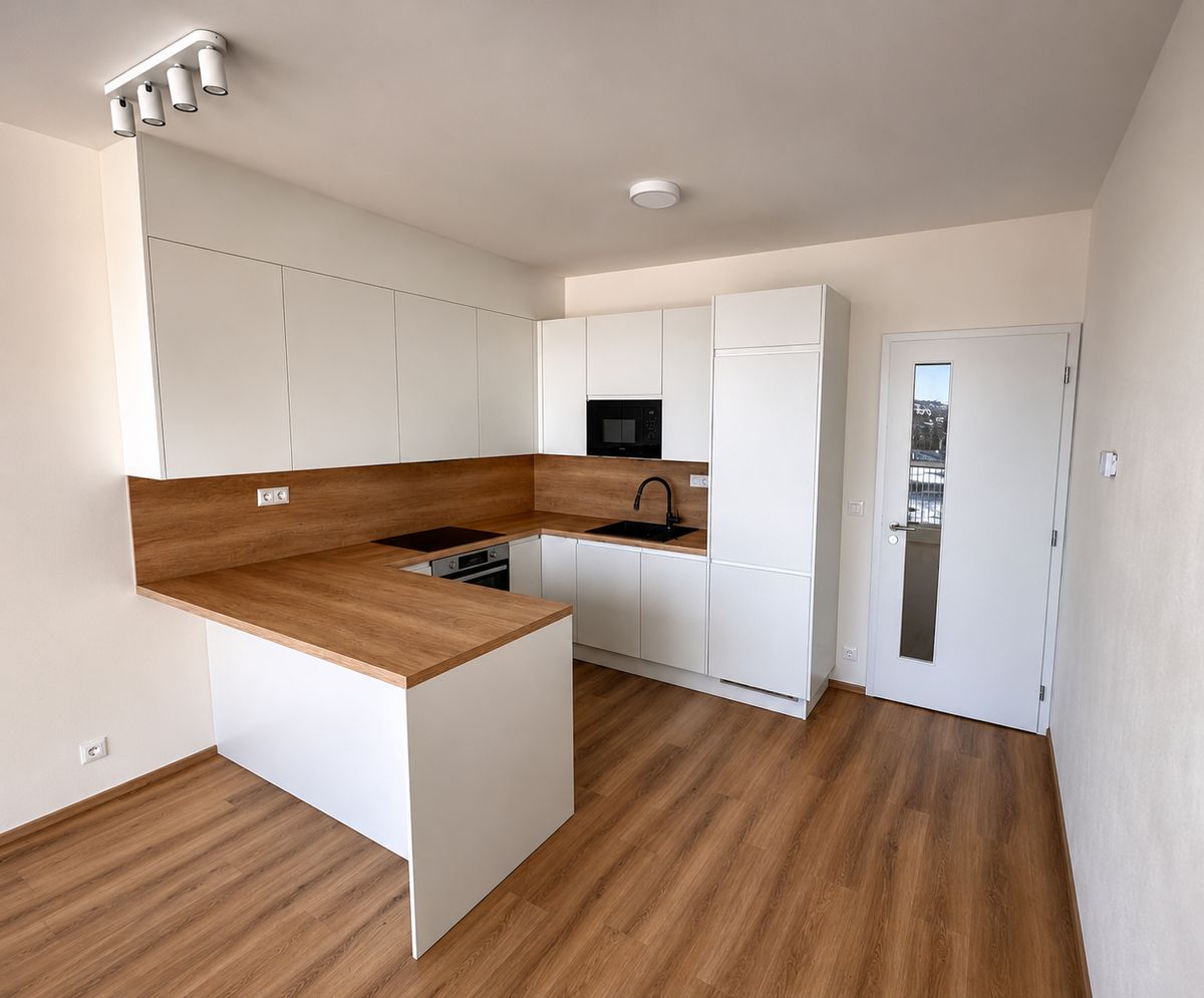 Neue Küche mit weissen Fronten, Arbeitsfläche in Holzoptik, eingebauter Mikrowelle und Boden in Holzoptik.
